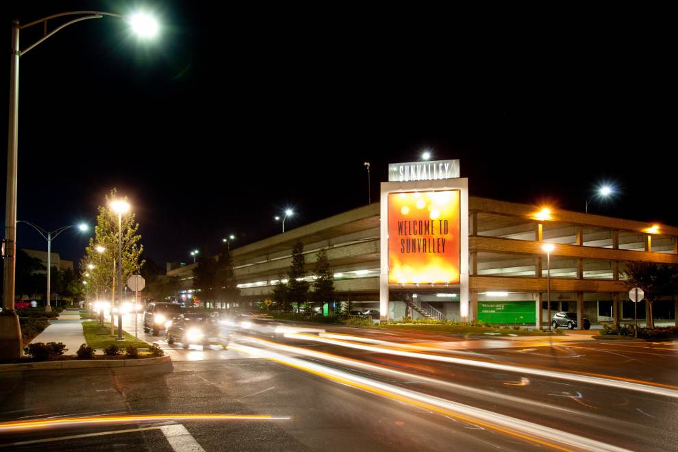 Cars drive past Sunvalley Mall at night