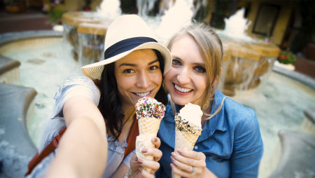 Two women holding icecream cones taking selfie together in Concord CA