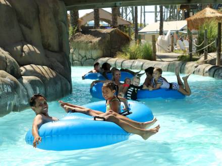 Family floating on blue tubes down a lazy river at Hurricane Harbor waterpark concord ca