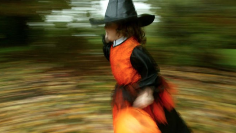 girl running in witch costume