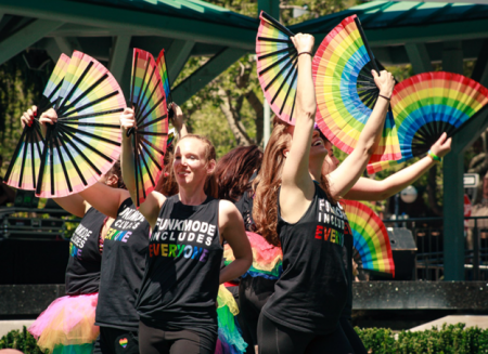 Group of dancers at Concord Pride festival holding rainbow fans while performing in Concord CA