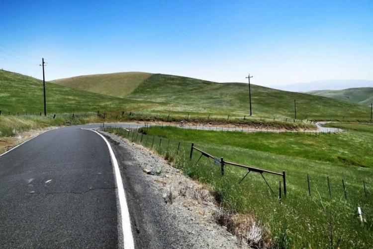 empty road weaves through hills