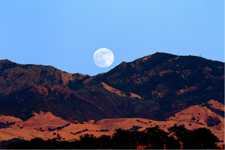 moon rising over mountains