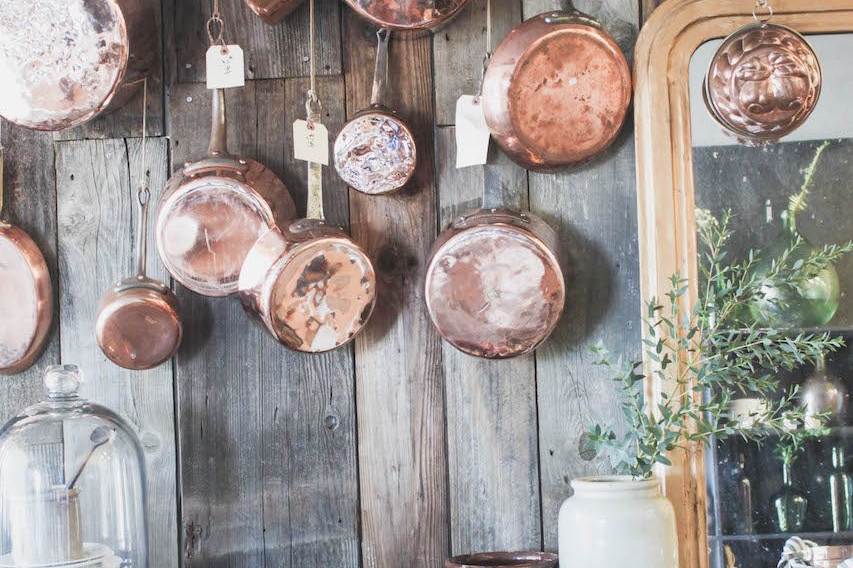 copper pots hanging on old wood wall