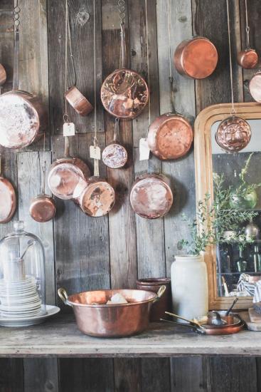 copper pots hanging on old wood wall