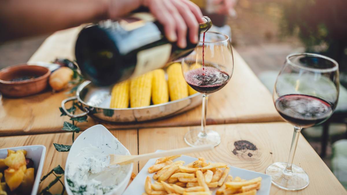 Pouring a glass of wine during a patio cookout