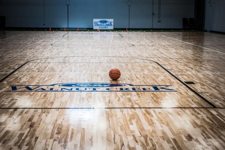basketball sits on empty wood court