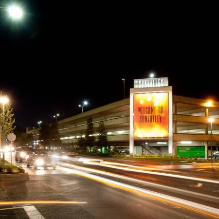 Cars drive past Sunvalley Mall at night