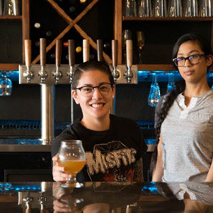 bartenders passing a beer