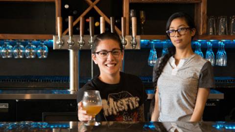 bartenders passing a beer