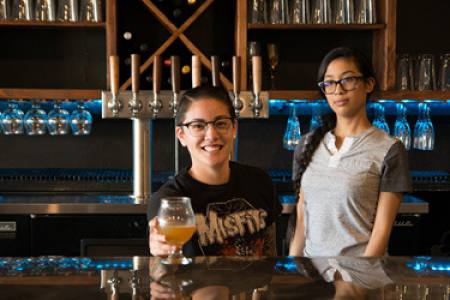 bartenders passing a beer