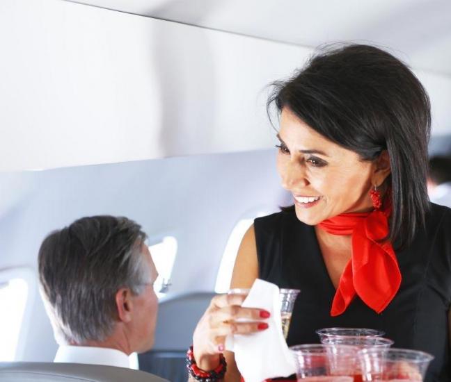 attendant serving drinks on plane