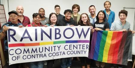 Group of people standing behind banner promoting the Rainbow Community Center in Concord CA